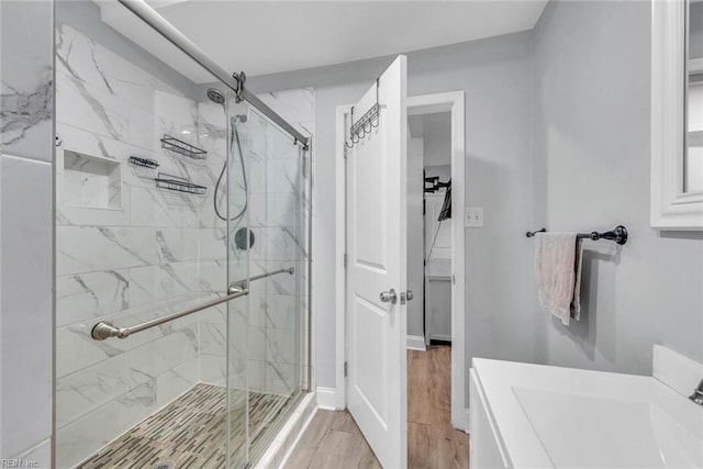 bathroom with hardwood / wood-style flooring, vanity, and an enclosed shower