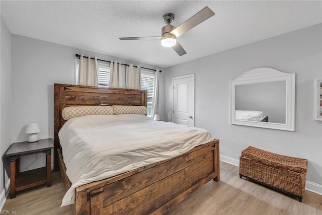 bedroom featuring ceiling fan, a textured ceiling, and light wood-type flooring