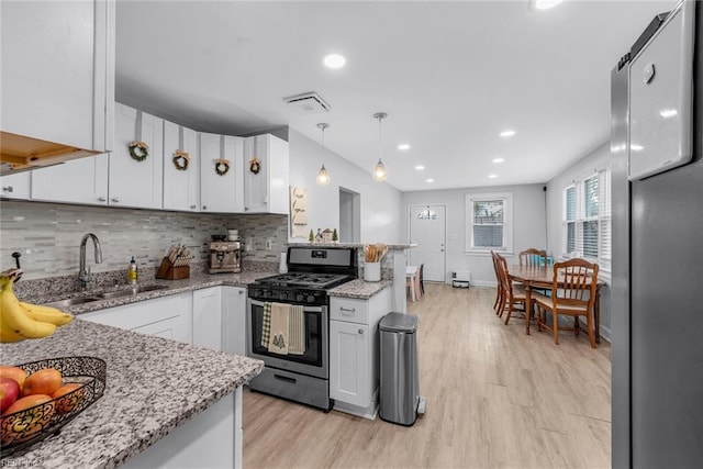 kitchen with white cabinetry, sink, decorative light fixtures, and appliances with stainless steel finishes