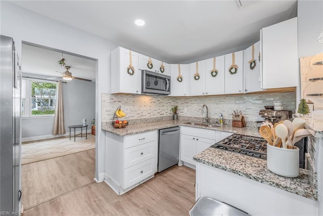 kitchen featuring light stone counters, stainless steel appliances, and white cabinets