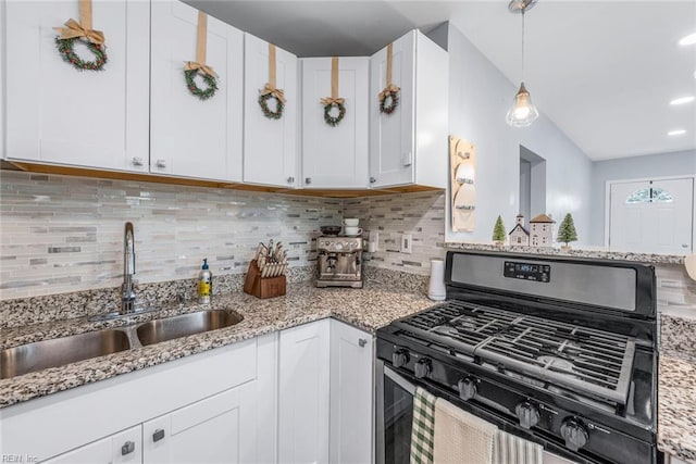 kitchen with pendant lighting, sink, vaulted ceiling, white cabinets, and range with gas cooktop