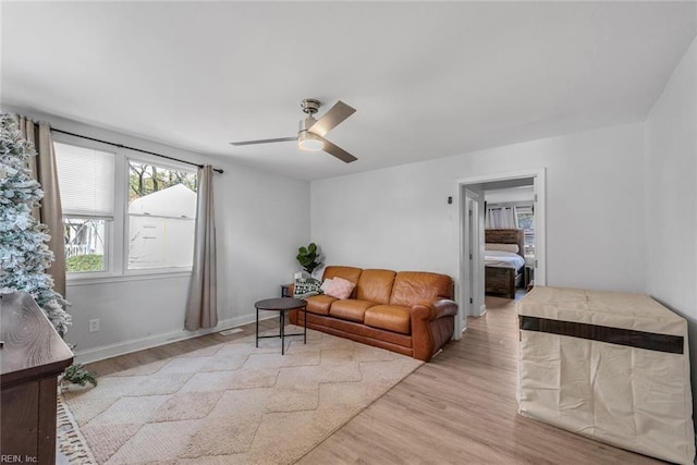 living room with ceiling fan and light hardwood / wood-style flooring