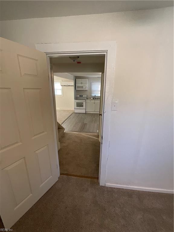 corridor with sink and dark carpet