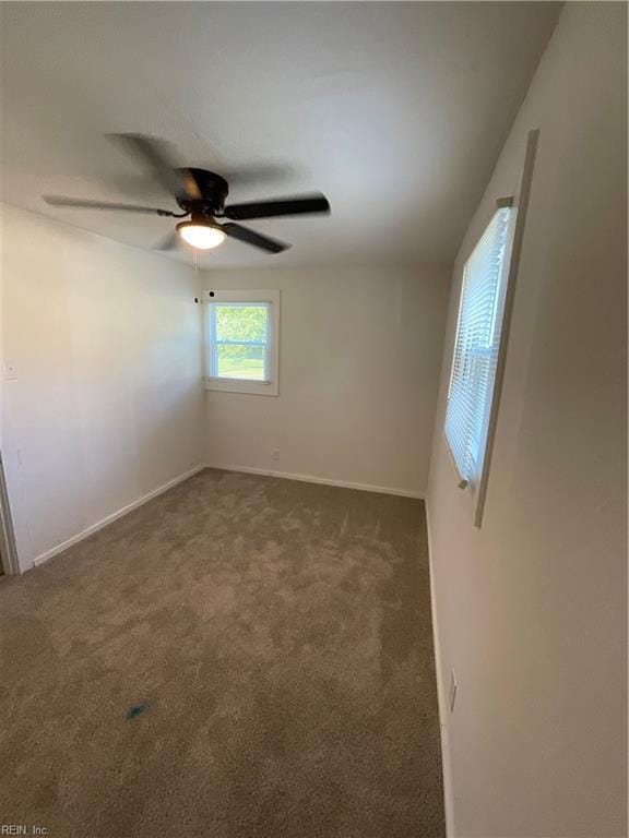 carpeted spare room featuring ceiling fan