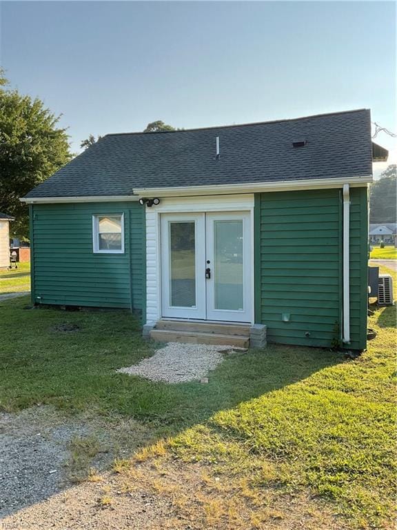 rear view of property with a yard, central air condition unit, and french doors