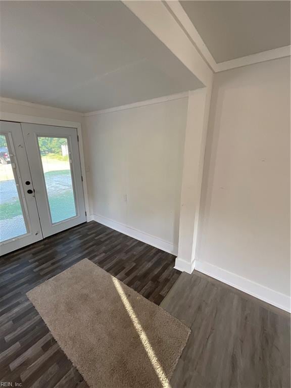 empty room featuring crown molding, dark wood-type flooring, and french doors