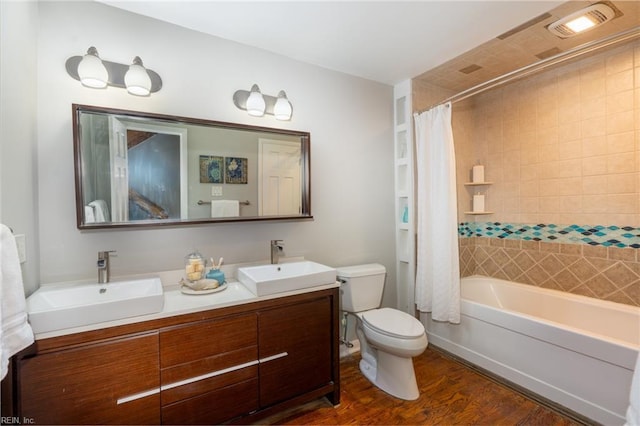 full bathroom with vanity, hardwood / wood-style flooring, toilet, and shower / bath combo