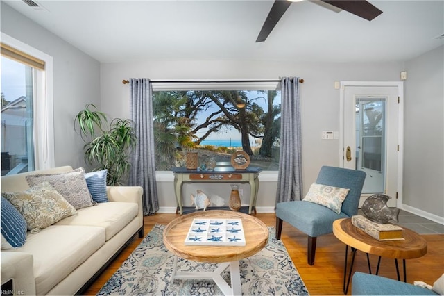 living area with wood-type flooring and ceiling fan