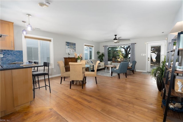 dining space with ceiling fan and light wood-type flooring