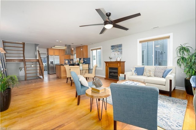 living room featuring light hardwood / wood-style flooring and ceiling fan