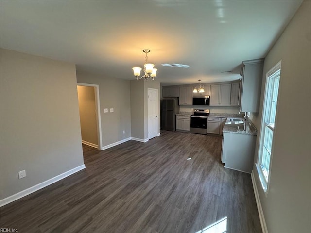 kitchen with gray cabinets, appliances with stainless steel finishes, a notable chandelier, dark hardwood / wood-style flooring, and decorative light fixtures