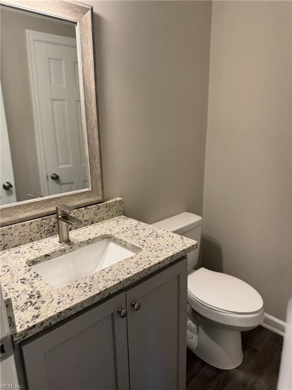 bathroom with vanity, toilet, and wood-type flooring