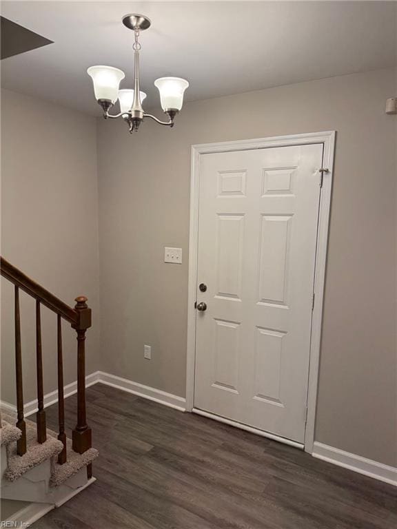 entryway featuring dark wood-type flooring and a notable chandelier