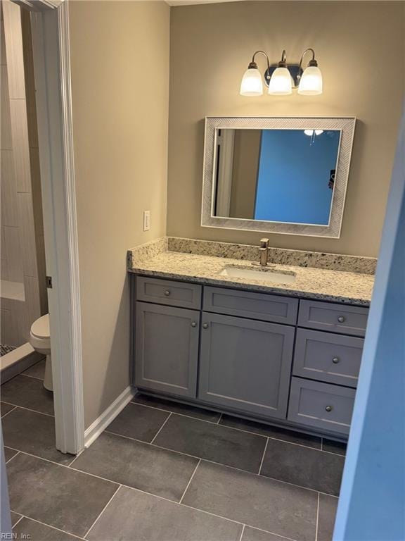 bathroom featuring vanity, tile patterned flooring, a shower, and toilet