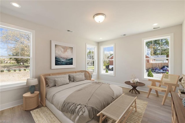 bedroom with multiple windows and light hardwood / wood-style floors