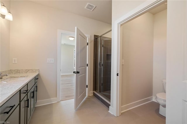 bathroom with vanity, toilet, and a shower with shower door