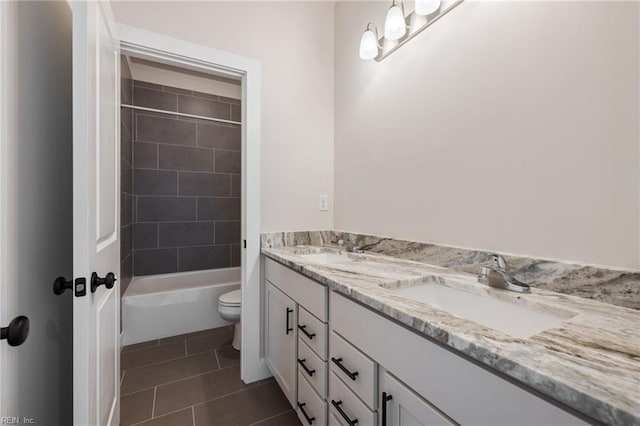 full bathroom featuring vanity, tiled shower / bath, tile patterned flooring, and toilet