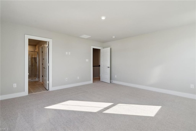 unfurnished bedroom with ensuite bathroom and light colored carpet