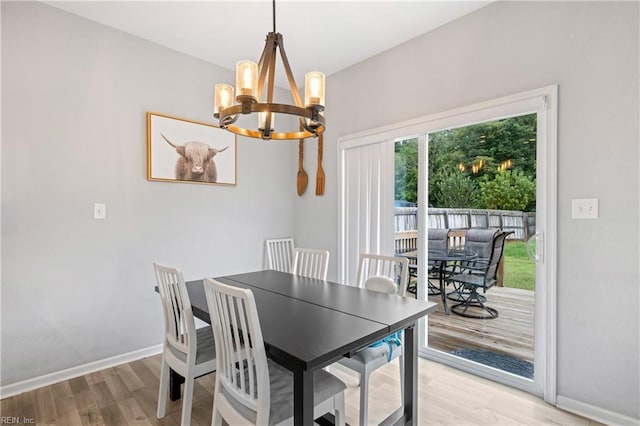 dining space featuring light hardwood / wood-style flooring and a chandelier