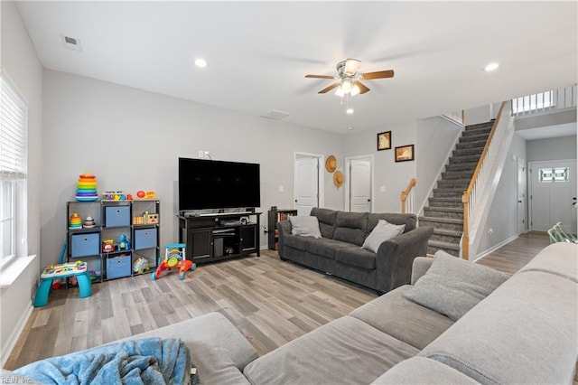 living room featuring plenty of natural light, ceiling fan, and light hardwood / wood-style flooring