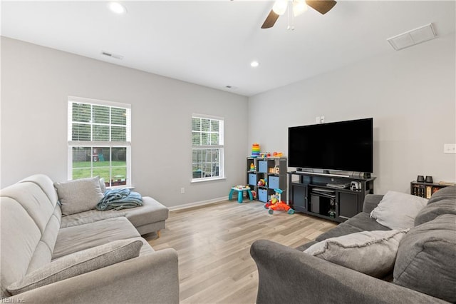 living room with ceiling fan and light wood-type flooring