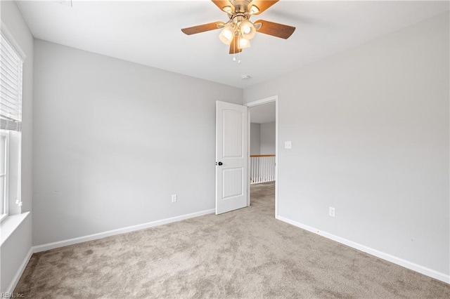 empty room featuring ceiling fan and light carpet