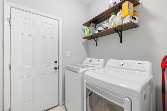 laundry room with washing machine and dryer and light tile patterned flooring