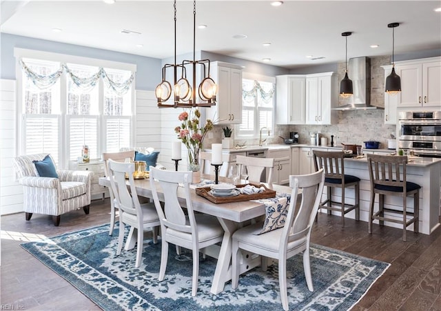 dining area featuring dark hardwood / wood-style floors, sink, and a notable chandelier