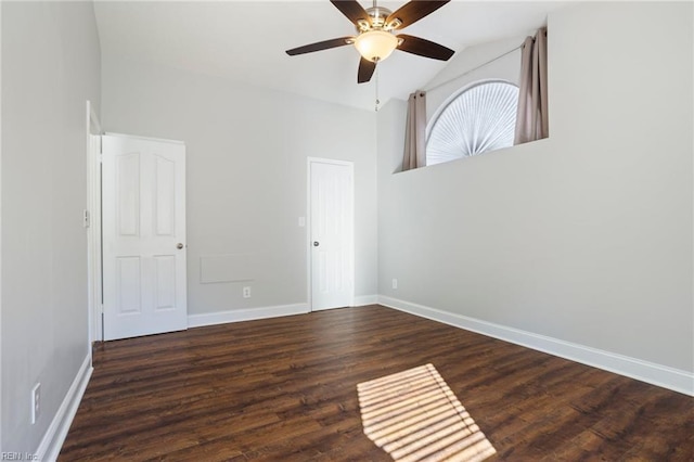 empty room with dark wood-type flooring, ceiling fan, and high vaulted ceiling