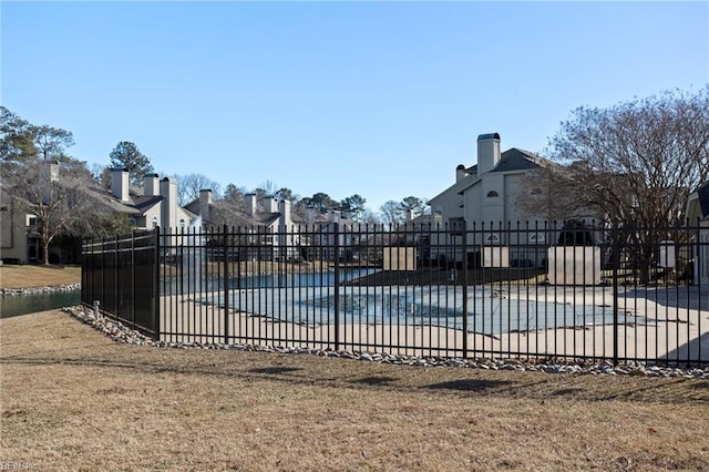 view of swimming pool featuring a water view, a lawn, and a patio area