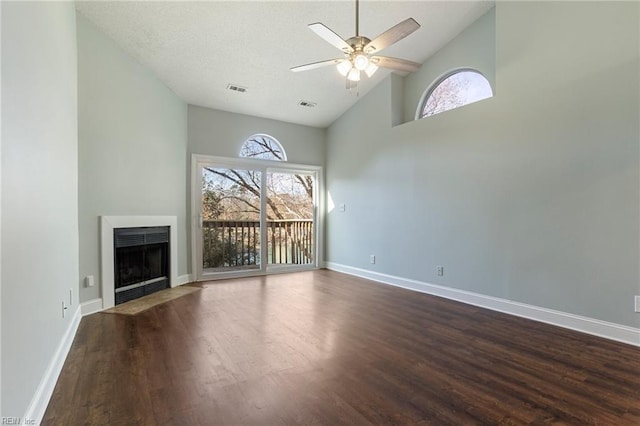 unfurnished living room with dark wood-type flooring, high vaulted ceiling, and ceiling fan