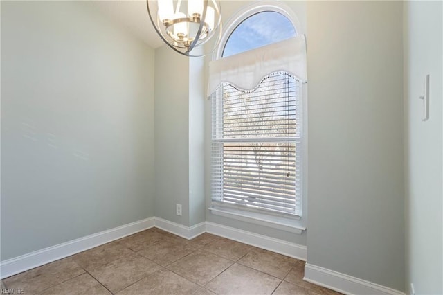 unfurnished room with light tile patterned flooring, plenty of natural light, and a chandelier