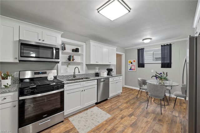 kitchen featuring sink, appliances with stainless steel finishes, light stone countertops, light hardwood / wood-style floors, and white cabinets