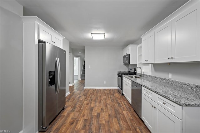 kitchen with white cabinetry, appliances with stainless steel finishes, dark wood-type flooring, and light stone counters