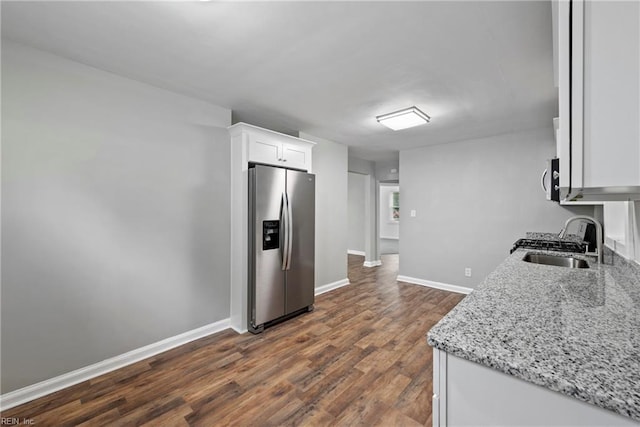 kitchen featuring white cabinetry, sink, dark hardwood / wood-style flooring, light stone counters, and stainless steel refrigerator with ice dispenser