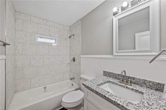 full bathroom featuring vanity, tiled shower / bath combo, and toilet