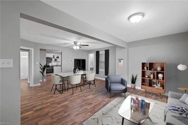 living room featuring ceiling fan, sink, and dark hardwood / wood-style flooring