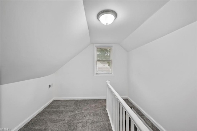 additional living space with lofted ceiling and dark colored carpet