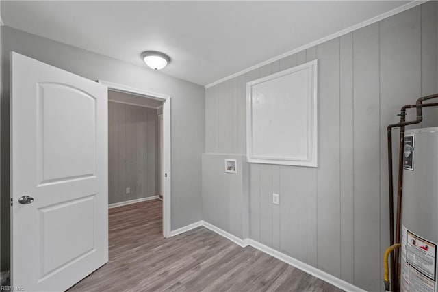 laundry room with hookup for a washing machine, water heater, and light wood-type flooring