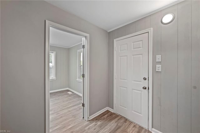 entrance foyer featuring ornamental molding and light hardwood / wood-style flooring