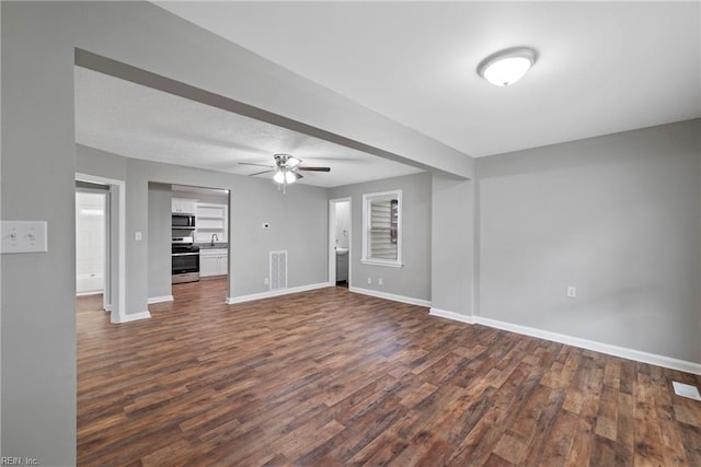 unfurnished living room featuring ceiling fan, dark hardwood / wood-style floors, and sink