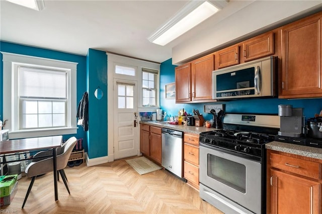 kitchen with stainless steel appliances and light parquet flooring