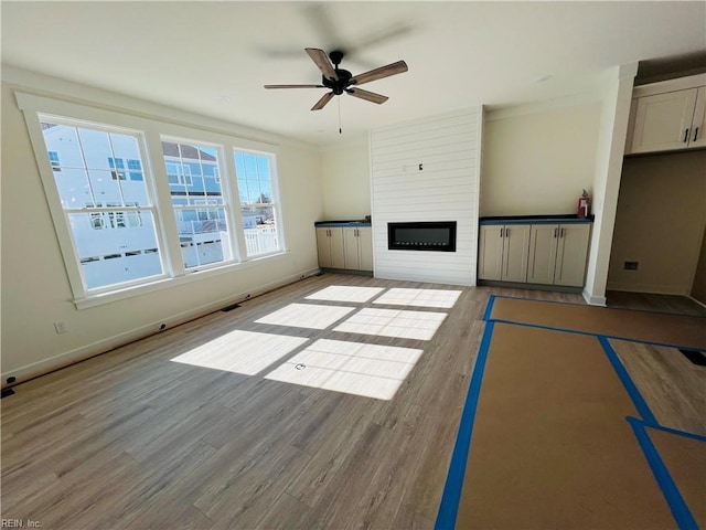 unfurnished living room with a fireplace, light hardwood / wood-style floors, and ceiling fan