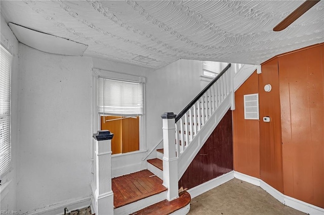 staircase featuring wooden walls