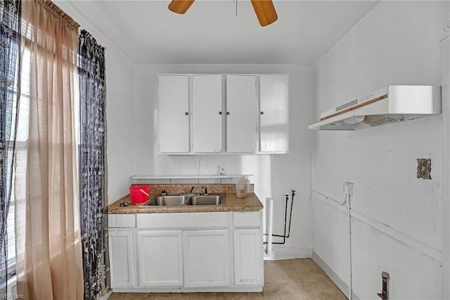 kitchen with ceiling fan, sink, and white cabinets