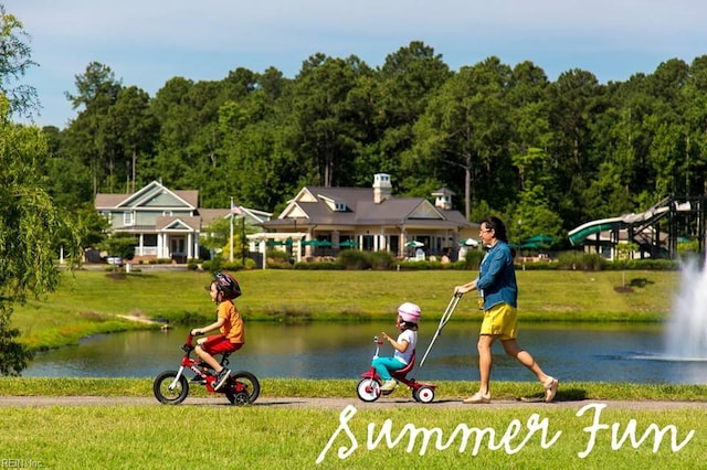 view of home's community with a water view and a lawn