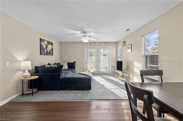 living room featuring ceiling fan, hardwood / wood-style floors, a textured ceiling, and a wealth of natural light