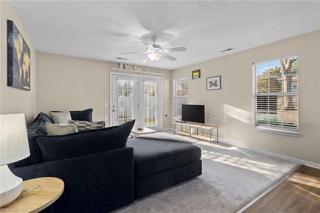 living room with ceiling fan, hardwood / wood-style floors, and a textured ceiling