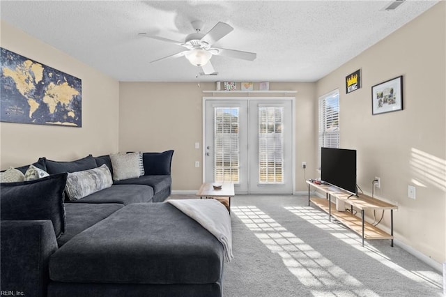 carpeted living room with ceiling fan, a textured ceiling, and french doors