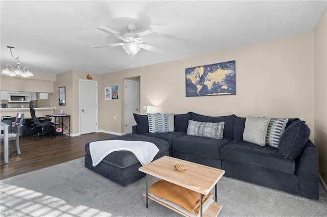 living room with ceiling fan with notable chandelier and carpet